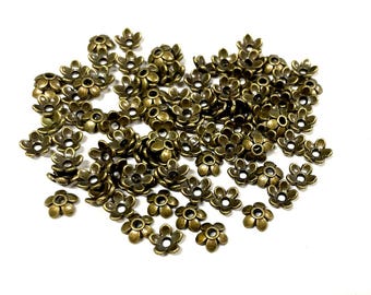 May include: A large quantity of bronze-colored metal flower-shaped beads. The beads have five petals and a small hole in the center.