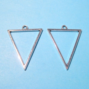 May include: Two silver triangle-shaped metal frames with a loop at the top. The frames are on a light blue background.