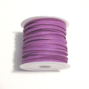 May include: A spool of purple suede cord, wound around a white plastic bobbin.
