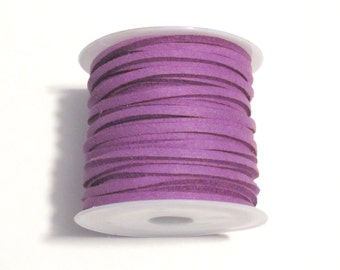 Peut inclure: Une bobine de cordon en daim violet, enroulée autour d'une bobine en plastique blanche.