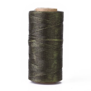 May include: A spool of dark green waxed thread.