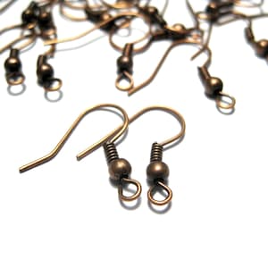 May include: A group of bronze-colored earring hooks with a small ball at the top of each hook.