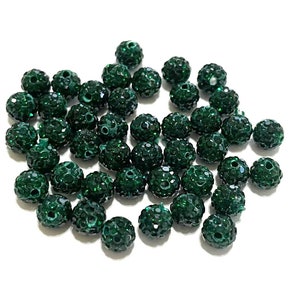 May include: A pile of dark green round beads with a sparkly finish. The beads are about 1/2 inch in diameter.