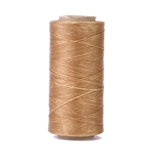 May include: A spool of tan waxed thread for leather crafting.