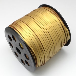 May include: A spool of gold leather cord, wound around a black plastic spool with holes for easy dispensing.