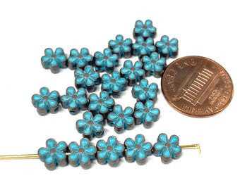 May include: A strand of turquoise blue flower-shaped beads with a copper finish. The beads are about the size of a US penny.