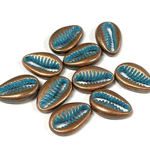 May include: Ten copper-colored shell-shaped beads with a turquoise blue interior. The beads are oval-shaped and have a raised design.