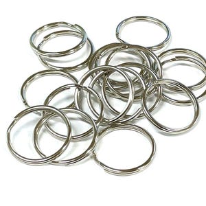 May include: A pile of silver key rings, a common hardware item used for attaching keys to a keychain.