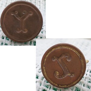以下が含まれることがあります： YとXの文字が刻まれた、アンティークな真鍮製のスタンプ2個。両方のスタンプは装飾的な縁取りが施されています。