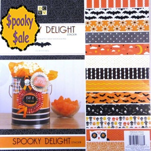 May include: A Halloween-themed paper stack with various patterns, including bats, skulls, and pumpkins. The stack is labeled "Spooky Delight" and features a decorative popcorn tin with a "Deadly Delicious" rosette.