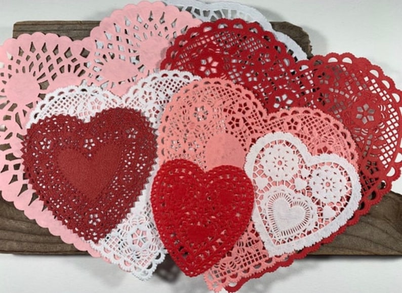 Peut inclure: Une collection de doilies en papier de forme c&oelig;ur, en rouge, rose et blanc. Les doilies sont d&eacute;licats et ont un design en dentelle.