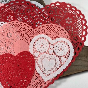 Peut inclure: Assortiment de doilies en papier en forme de c&oelig;ur rouge, rose et blanc avec des motifs de dentelle complexes.