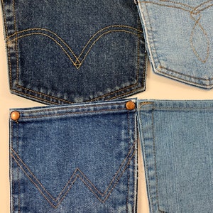 May include: Four different denim jean pockets with contrasting stitching. The pockets are all blue, but the shades of blue vary. The pockets have different stitching designs, including a classic curved design and a more modern zig-zag design.