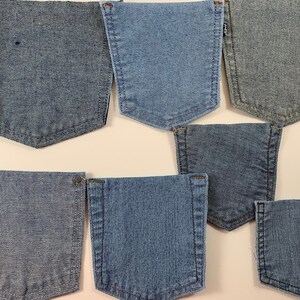 May include: Eight different denim fabric swatches, each showing a different weave and shade of blue. The swatches are arranged in two rows of four, with the top row showing a lighter shade of blue and the bottom row showing a darker shade of blue.