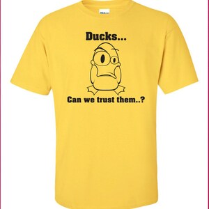 May include: Yellow t-shirt with a black cartoon duck and the text "Ducks... Can we trust them...?"
