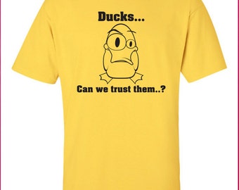 May include: Yellow t-shirt with a black cartoon duck and the text "Ducks... Can we trust them...?"