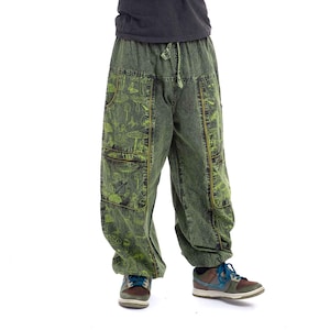 May include: A long-sleeve black crew neck shirt paired with loose-fitting olive green cargo trousers featuring a lime green mushroom and nature-themed print, an elastic drawstring waistband, and large side pockets, worn with multi-coloured trainers.