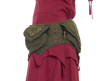 May include: A green canvas belt with multiple pockets and decorative metal accents. The belt is worn over a burgundy dress with a ruffled hem.