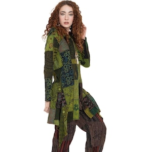 Könnte beinhalten: Eine Frau trägt eine lange, grüne Patchworkjacke mit Kapuze und eine braune und schwarze gemusterte Hose. Sie trägt bunte gemusterte Schuhe.