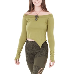 Può includere: Una donna indossa una camicia verde a maniche lunghe con spalle scoperte e leggings con motivo verde e nero. La camicia ha un orlo a punta e i leggings hanno delle fessure sulle gambe.