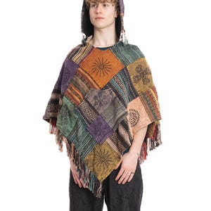 May include: A patchwork poncho with a hood, featuring a variety of colors and patterns. The poncho has a fringed hem and is worn by a person. The design includes sun and geometric motifs.