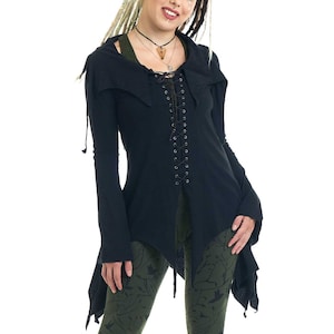 Könnte beinhalten: Ein schwarzes Kapuzenoberteil mit Schnürung vorne und einem langen, fließenden Saum. Das Oberteil wird über einer grünen Leggings mit Vogel- und Astmuster getragen.