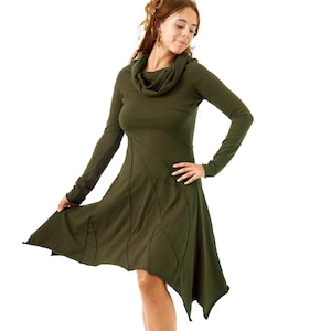Può includere: Abito verde oliva a maniche lunghe con collo a cappuccio e orlo asimmetrico. L'abito presenta un design unico con linee cucite che creano una silhouette lusinghiera. La persona indossa scarpe nere.