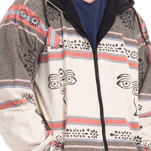 May include: A gray and white hooded jacket with a black zipper and a patterned design. The pattern includes red, blue, and black stripes, as well as stylized eyes and floral motifs.