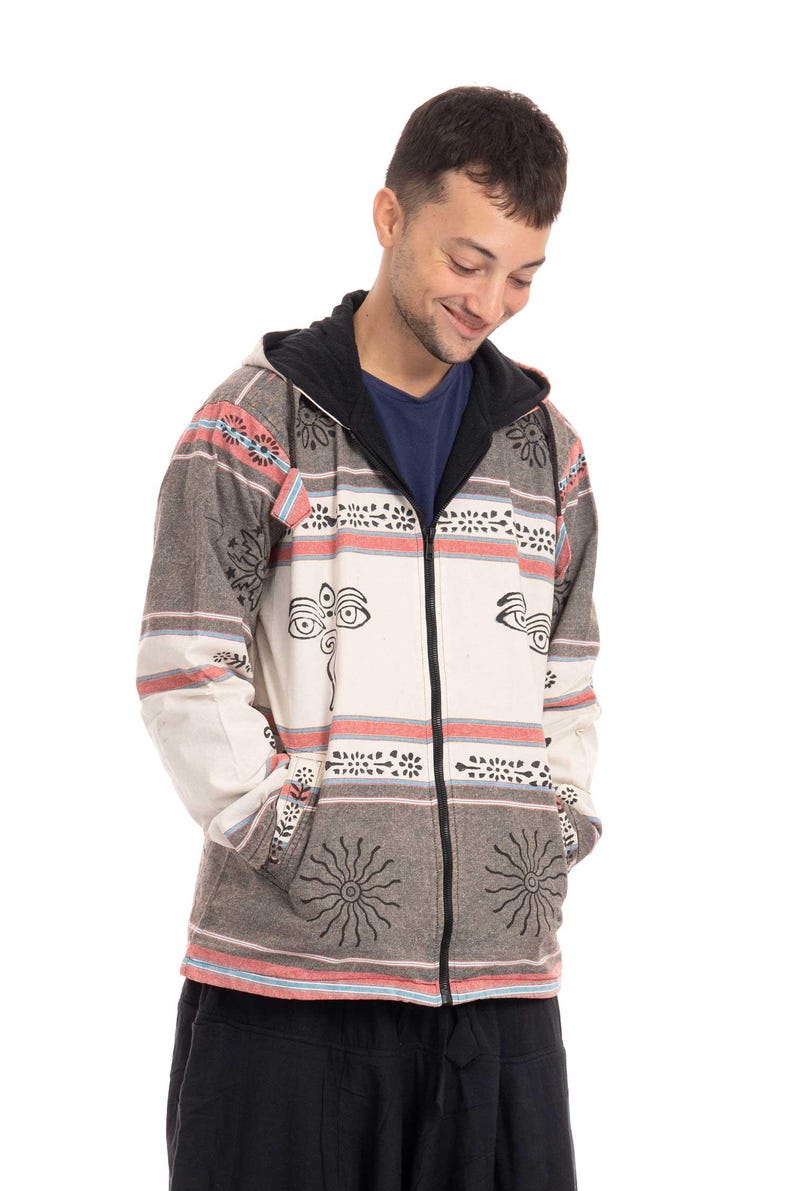 May include: A gray and white hooded jacket with a zipper closure and a patterned design featuring black eyes and suns. The jacket has a black hood and is made of a soft, comfortable fabric.