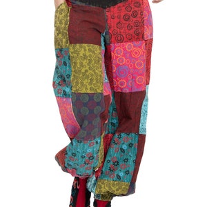 May include: Patchwork trousers with a colourful, geometric pattern. The trousers have a wide leg and a low rise. The fabric is a blend of cotton and linen.