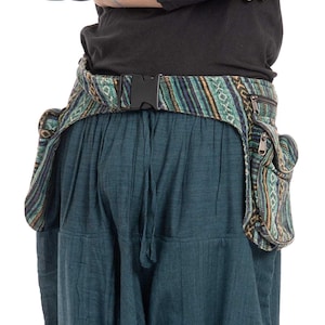 May include: A teal blue pair of trousers with a patterned fabric belt and two fabric pouches attached to the belt. The belt has a black buckle.
