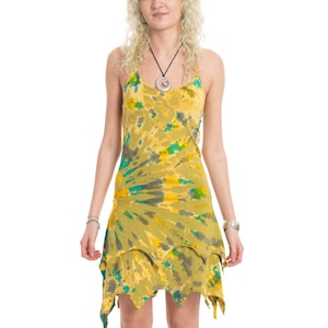 Puede incluir: Un vestido sin mangas con un patrón de teñido anudado en tonos amarillo mostaza, gris oscuro y verde brillante. La prenda tiene tirantes finos y un dobladillo superpuesto estilo pañuelo que cae por encima de las rodillas con bordes puntiagudos.