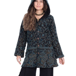 Könnte beinhalten: Eine langärmelige Kapuzenjacke mit einem floralen Muster in Blautönen, Schwarz und Gold. Die Jacke hat einen Knopfverschluss und eine lockere Passform.