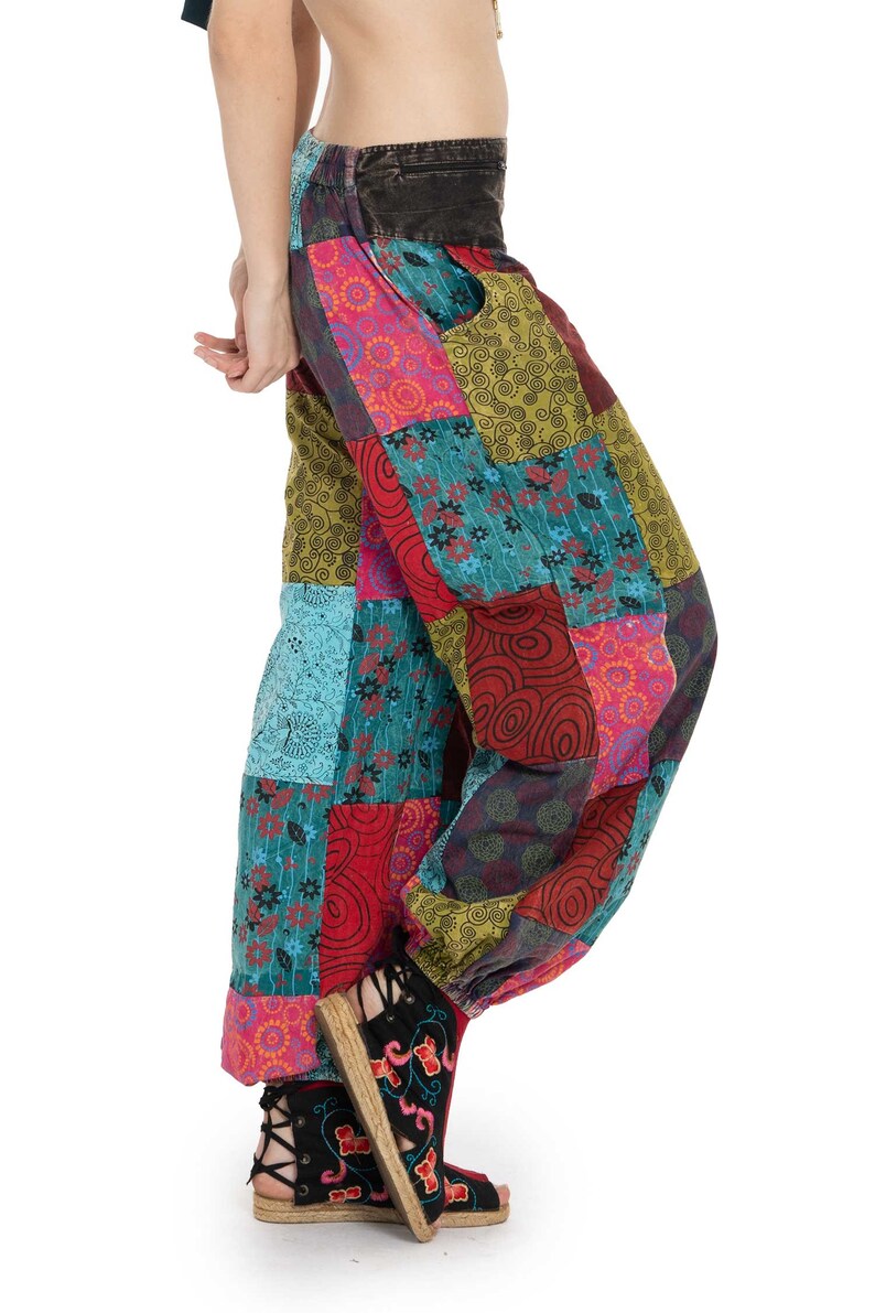 May include: Patchwork trousers with a colourful, geometric pattern in shades of red, blue, green, and pink. The trousers are loose-fitting and have a wide leg.