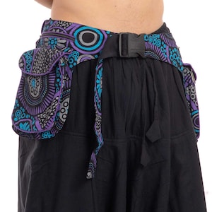 May include: A black fabric belt with a purple and blue patterned design. The belt has a buckle and two pockets on the sides. The pockets are also patterned with purple and blue.