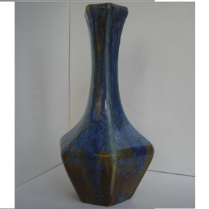 May include: A blue and brown ceramic vase with a geometric shape and a speckled glaze.