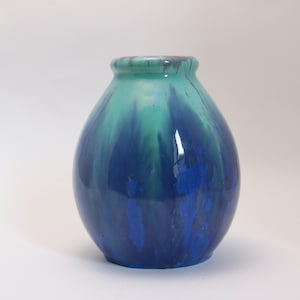 May include: A blue and green ceramic vase with a rounded body and a smooth, glossy finish.