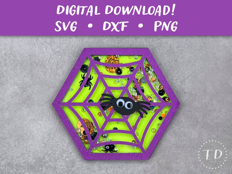 May include: Purple hexagon-shaped cutout of a spider web with a green background and a black spider with googly eyes. The web is filled with glitter and beads.