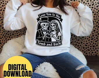May include: White sweatshirt featuring a black graphic of a skeleton couple with the text "Love You to the Tomb and Back." The design includes a skeleton groom in a top hat and a skeleton bride in a veil. A yellow circle with the words "DIGITAL DOWNLOAD" is at the bottom.