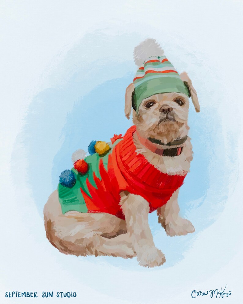 May include: A small, light brown dog wearing a red and green sweater with white pom-poms and a green and white striped hat with a white pom-pom on top. The dog is sitting on a light blue background.