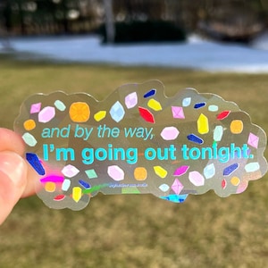May include: A clear sticker with a holographic finish and colorful confetti-like shapes. The sticker has the text "and by the way, I'm going out tonight."