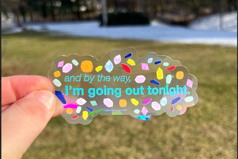 May include: A clear sticker with a holographic finish and colorful confetti-like shapes. The sticker has the text "and by the way, I'm going out tonight."