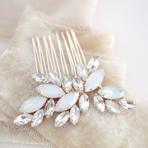 May include: A silver hair comb with a cluster of clear and opaque white crystals in a floral design.