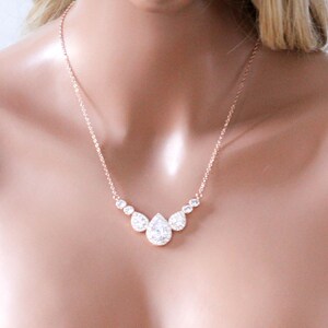 Pu&ograve; includere: Una collana in oro rosa con un ciondolo a forma di lacrima incastonato con pietre di zircone cubico trasparenti.
