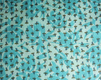 May include: A turquoise fabric with a repeating pattern of small blue and green leaves. The fabric has a subtle texture and a light, airy feel.