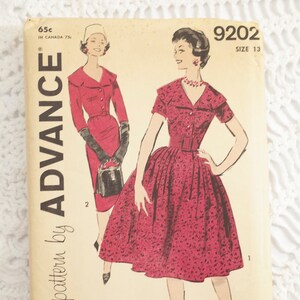 May include: Vintage sewing pattern for a dress, featuring two models wearing red dresses. The pattern is from Advance, number 9202, size 13. The text "a printed pattern by ADVANCE" is on the left side of the pattern.
