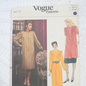 Può includere: Modello di cucito Vogue Patterns per tre abiti. Il modello mostra tre donne che indossano diversi stili di abiti. Il primo abito è un abito dorato a maniche lunghe con scollo rotondo. Il secondo abito è un abito giallo a maniche lunghe con scollo rotondo e cintura. Il terzo abito è un abito rosa a maniche corte con scollo rotondo.