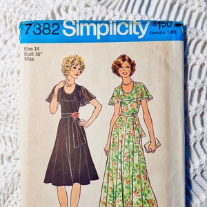 May include: Vintage Simplicity sewing pattern, size 14, bust 36 inches. The pattern features illustrations of two dresses: a black dress with a floral belt and a floral print dress. The pattern is labeled "7382 Simplicity".