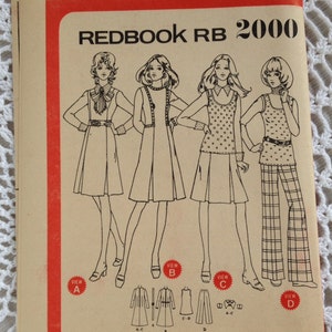 Puede incluir: Un folleto de patrones de costura vintage, "REDBOOK RB 2000", con un borde rojo. La portada muestra dibujos lineales de cuatro conjuntos, incluyendo vestidos, un abrigo y pantalones, al estilo de los años 70. El fondo es de color crema.