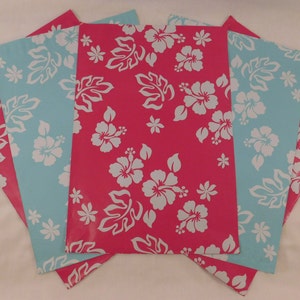 May include: Four sheets of wrapping paper with a tropical floral pattern. The paper is pink with white hibiscus flowers and leaves. The back of the paper is light blue with white hibiscus flowers and leaves.
